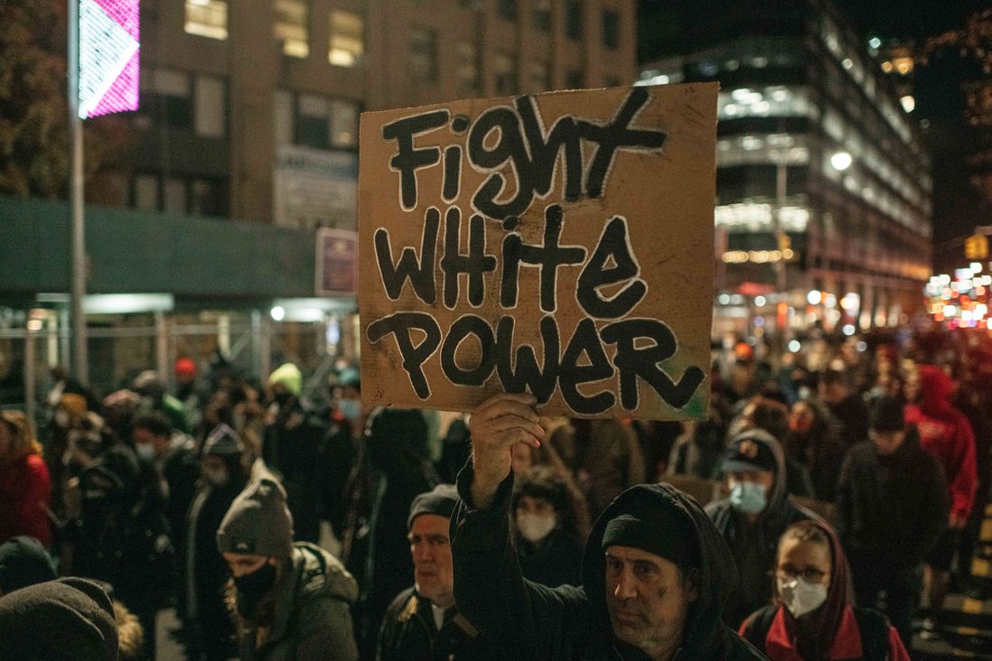 A protester holds a sign reading, "Fight white power" during a demonstration against the not guilty verdict for Kyle Rittenhouse.